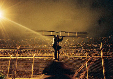 Inmigrante Camerunes saltando la valla que separa Africa de Europa.