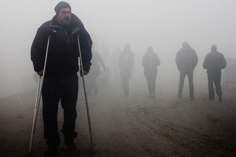 00020 vàris refugiats caminen entre la boira en la que s'ha despertat avui el camapent d' Idomeni